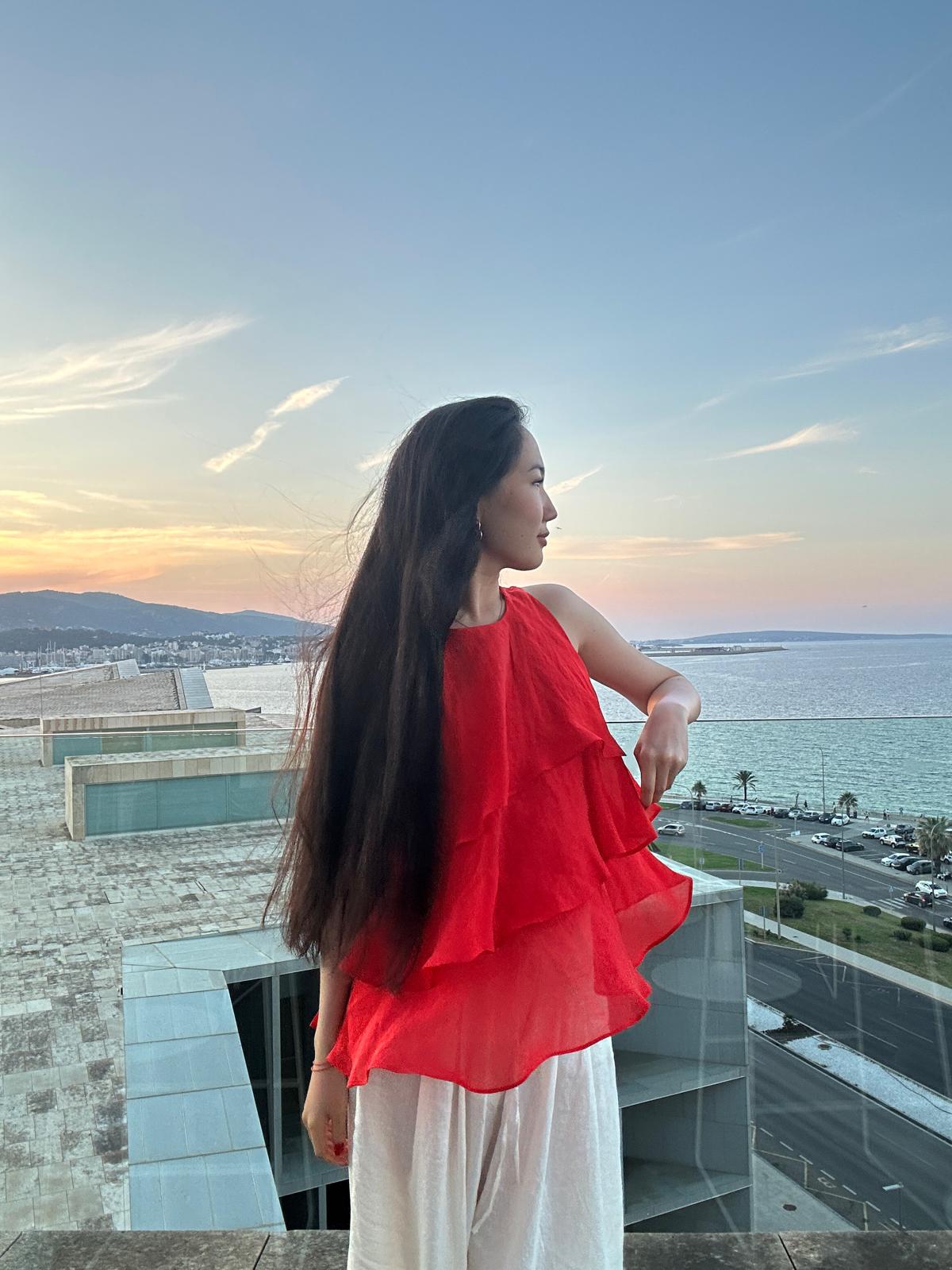 Saadat Asanbaeva looking out over the sea at sunset